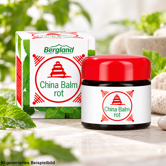Bergland China Balm rot mit rotem Deckel und Verpackung in hellem Wellness-Ambiente mit frischen grünen Kräutern, Naturstein und weichem Hintergrund.