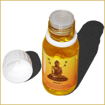 NUAD Öl ganzheitliches naturreines Hautpflegeöl in geöffneter 60-ml-Flasche mit abgenommenem weißem Verschluss und goldgelbem Pflegeöl.