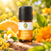 Primavera Gute Laune Duftmischung in brauner Glasflasche, dekoriert mit Orange, Zitrusblüten und gelben Blüten in sonniger natürlicher Umgebung.