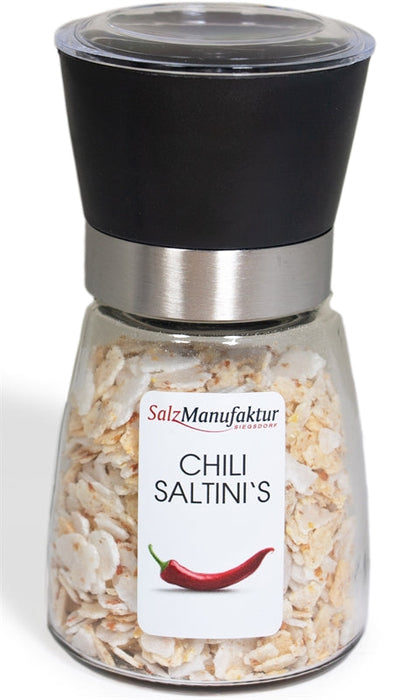 SalzManufaktur Siegsdorf Chili Saltini's in einer transparenten Gewürzmühle mit schwarzem Mahlwerk, gefüllt mit groben Salzstücken und roten Chilistücken, auf weißem Hintergrund.