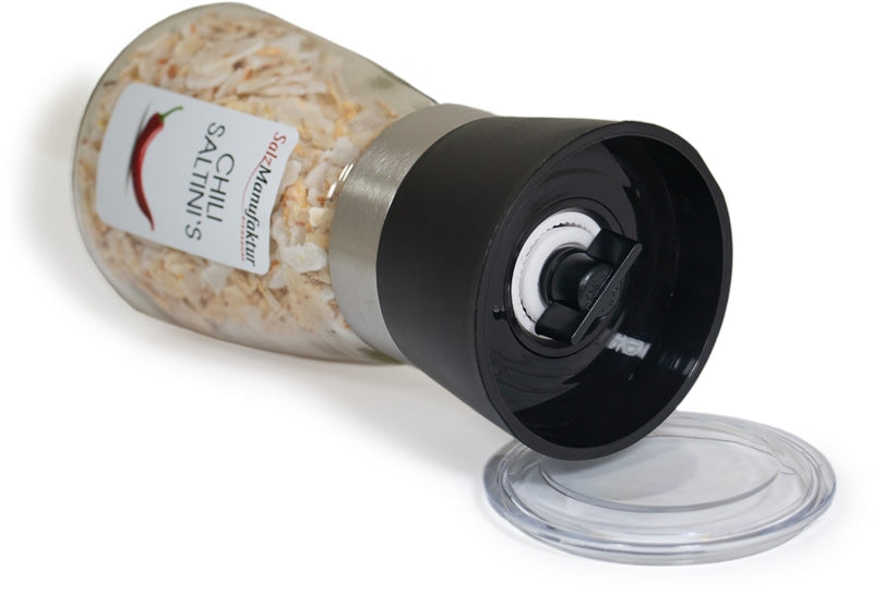 SalzManufaktur Siegsdorf Chili Saltini's Gewürzmühle in liegender Position mit abgenommenem transparentem Schutzdeckel und sichtbarem schwarzem Mahlwerk.