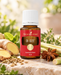 Young Living Di-Gize Essential Oil Blend 15 ml, dekoriert mit Ingwer, Sternanis, Fenchelsamen, Zitronengras und frischen Kräutern auf hellem Naturstein.