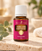 Young Living Purification Essential Oil Blend 15 ml in brauner Glasflasche mit weißem Verschluss auf hellem Naturstein in warmem Spa-Ambiente.
