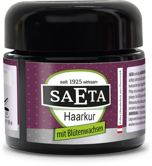 SAETA Haarkur mit Blütenwachsen 100 ml in schwarzem Kosmetiktiegel mit glänzendem Schraubdeckel und violett-grünem Originaletikett, freigestellt vor weißem Hintergrund.