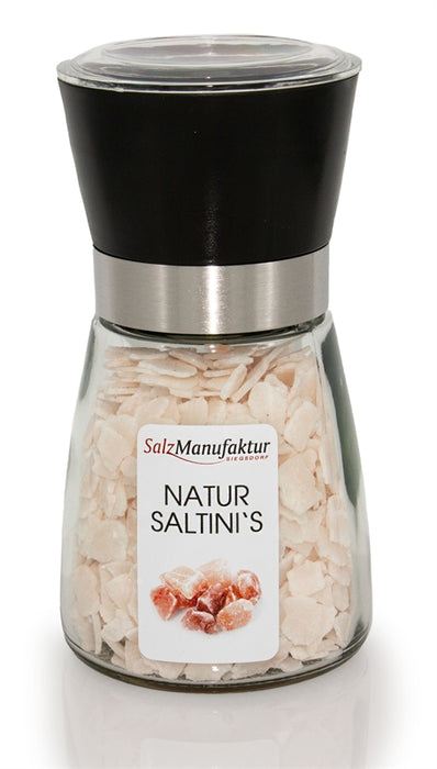SalzManufaktur Siegsdorf Natur Saltini's in einer großen, transparenten Gewürzmühle mit schwarzem Mahlwerk und Edelstahlring, gefüllt mit naturbelassenen Salzstücken.