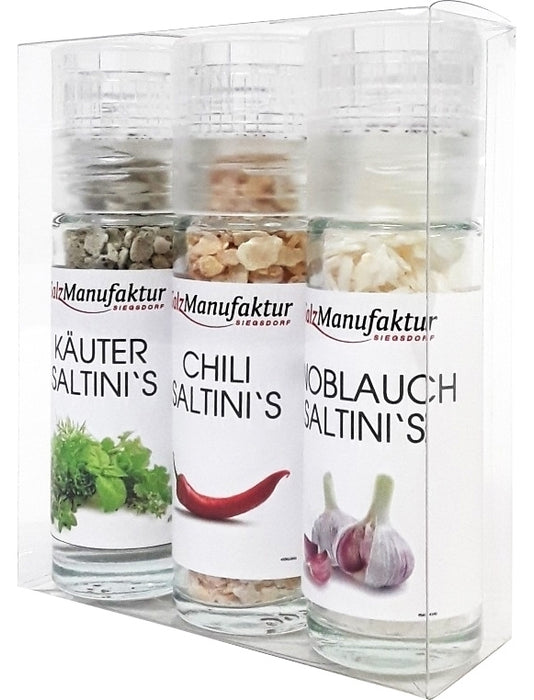SalzManufaktur Siegsdorf Saltini’s 3er Set mit Kräuter-, Chili- und Knoblauch-Salzflocken in drei Gewürzmühlen, verpackt in transparenter Geschenkbox vor hellem Hintergrund.